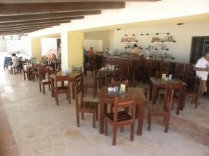 un restaurante con mesas y sillas de madera y un bar en Cancun Beach ApartHotel by Solymar, en Cancún