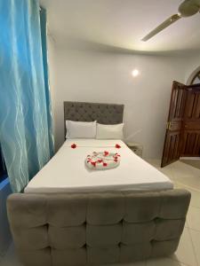 a bedroom with a bed with roses on it at Hello Rafiki Hotel Stone town in Ngambo +22 photos
