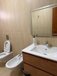 a bathroom with a sink and a toilet and a mirror at Maya's home Tirana in Tirana