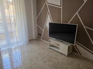 a flat screen tv sitting on a stand in a living room at House raffy in San Severo