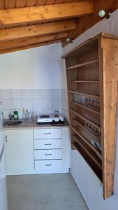 a kitchen with white counters and wooden ceilings at Serafima's house Lesvos in Sykaminéa