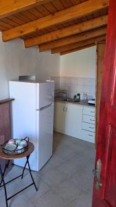 a kitchen with a white refrigerator and a table at Serafima's house Lesvos in Sykaminéa