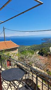 a table on a balcony with a view of the ocean at Serafima's house Lesvos in Sykaminéa