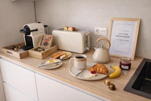 a kitchen counter with bread and croissants and a toaster at VILLA PANGEA - Guest House - Camino del Norte in Castro-Urdiales