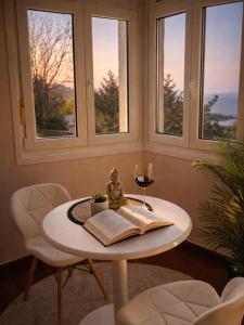 a table with a book and a glass of wine at VILLA PANGEA - Guest House - Camino del Norte in Castro-Urdiales