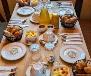 a table topped with plates and bowls of food at L'Authentique in Beaumont-le-Roger