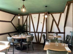 a dining room with wooden tables and chairs at L'Authentique in Beaumont-le-Roger