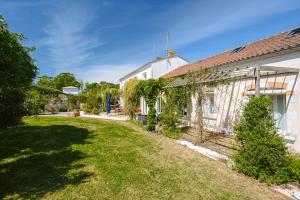 an empty yard next to a white house at Maison d'hotes Les Cagouilles in Virson