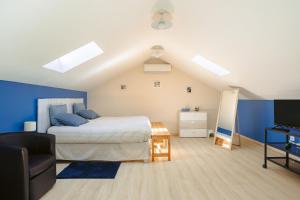 a bedroom with a bed with blue walls and a television at Maison d'hotes Les Cagouilles in Virson