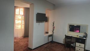 a room with a desk and a tv on a wall at Hotel Cash in Tbilisi City