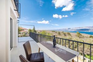 a balcony with a table and chairs and a view of the water at Seaview apartments Refugium Krk in Polje