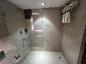 a bathroom with a shower with a glass door at ALOHA ON SACRED GANGES 2BHK Premium Ganga View Apartment with Infinity Pool in Rishīkesh