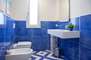 a blue tiled bathroom with a sink and a toilet at Isabel Luxury Suite in Ischia