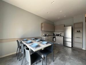 a kitchen with a table and chairs in a room at Appartamento Ideal con piscine e animazione Hotel Alba d Oro estate in Gatteo a Mare +10 photos