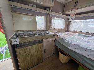 a kitchen in an rv with a sink and a bed at Bed and Breakfast Reestdal in Meppel +6 photos
