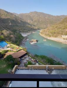 a view of a river with mountains in the background at ALOHA ON SACRED GANGES 2BHK Premium Ganga View Apartment with Infinity Pool in Rishīkesh +4 photos