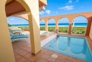 a villa with a swimming pool and the ocean at Villa Afreen Playa in Morro del Jable