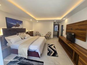 a bedroom with a large bed and a flat screen tv at Hotel Royal Badri - A Pilgrim's Habitat in Badrinath +4 photos