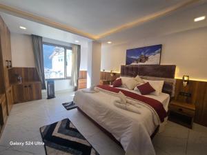 a bedroom with a large bed and a large window at Hotel Royal Badri - A Pilgrim's Habitat in Badrinath