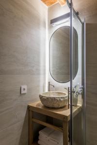 a bathroom with a stone sink and a mirror at Marketos Windmill House in Tripiti