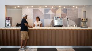 a man and a woman standing at a counter at Canvas by Mitsis Belvedere in Benitses