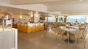 a dining room with tables and chairs in a restaurant at Canvas by Mitsis Belvedere in Benitses