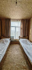 an empty room with two beds and a window at Yurt camp Visit Kol-Suu in Kol-Suu
