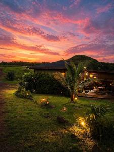 a house with a palm tree in front of a sunset at Sunset Calm Retreat Bungalow in Haleiwa