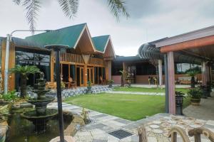 a house with a fountain in the middle of a yard at MIK Resort & Hotel in Pasuruan