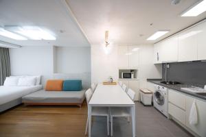 a kitchen and living room with a couch and a table at Ciel de Mer in Busan