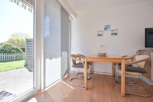 a dining room with a table and chairs and a window at Ferienhaus Keona Im Winkel in Dahme