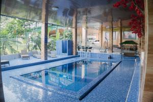 a large swimming pool with blue tiles in a building at MIK Resort & Hotel in Pasuruan