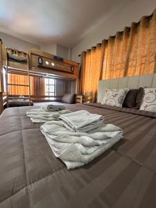 a bedroom with a bed with towels on it at Mata Villa Krabi Town in Krabi