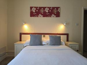 a bedroom with a large white bed with blue pillows at Villa Nova in Saint Helier Jersey