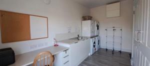 a white kitchen with a sink and a dishwasher at Housegarth in Twatt +4 photos