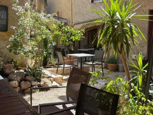 a patio with a table and chairs and plants at Le Clos d'Orange - Hotel & ville de Provence in Orange