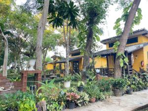 a yellow house with plants in front of it at Moonlit Garden Koh Chang in Ban Dan Kao