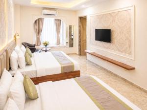 a hotel room with two beds and a flat screen tv at Solenne Retreat in Bodh Gaya