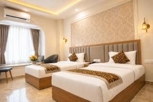 a hotel room with two beds and a window at Solenne Retreat in Bodh Gaya