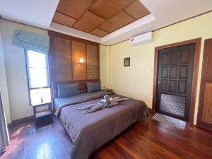 a bedroom with a bed and a window and a door at Moonlit Garden Koh Chang in Ban Dan Kao