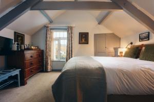a bedroom with a large bed and a window at Port Gaverne Hotel in Port Isaac