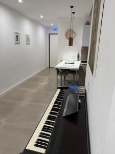 a black piano in a room with a table at B&B Sparta in Crotone