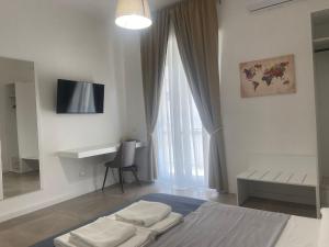 a bedroom with a bed with a desk and a window at B&B Sparta in Crotone