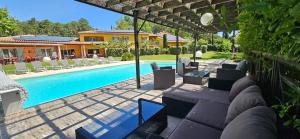 a swimming pool with chairs and a house at Les Sables d'Ocre & SPA in Roussillon