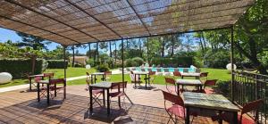 a patio with tables and chairs on a deck at Les Sables d'Ocre & SPA in Roussillon +31 photos