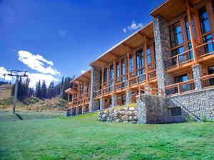 a large wooden building with a grass field in front of it at Sunshine Mountain Lodge in Banff