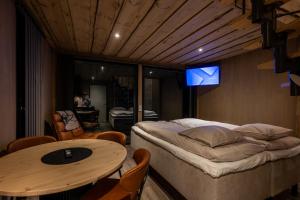 a room with a bed and a table in it at Aurora Lake Lodges in Ranua