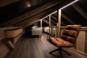 a room with a chair and a room with beds at Aurora Lake Lodges in Ranua +1 photo