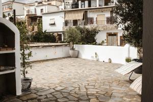 a courtyard with a white wall and a stone patio at Casa Yegen in Yegen