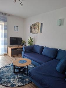 a living room with a blue couch and a table at Enjoy in Omiš